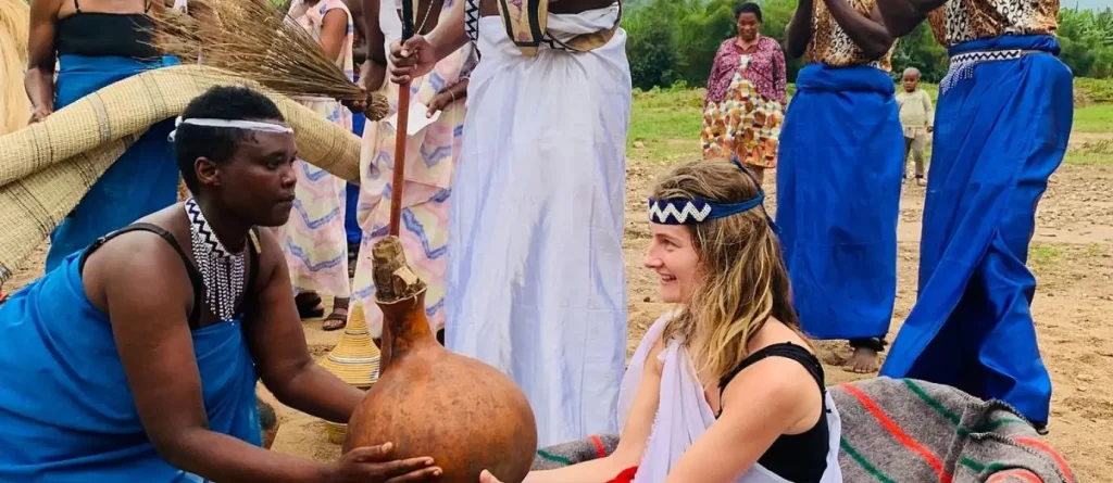 Participants engaging in a hands-on cultural exchange tour in Rwanda, learning traditional dance and wedding customs.