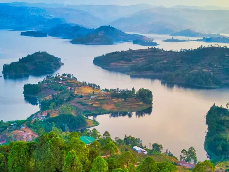 A serene view of Lake Bunyonyi, surrounded by terraced hills and dotted with lush green islands in southwestern Uganda.