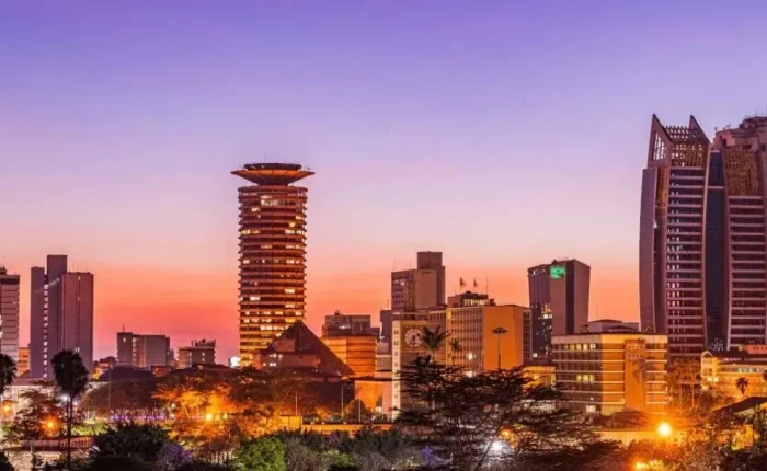 A stunning view of Nairobi's skyline featuring modern skyscrapers illuminated under the vibrant hues of a sunset.